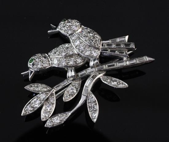 A white gold, diamond and garnet brooch, modelled as two birds on a branch, 1.5in.